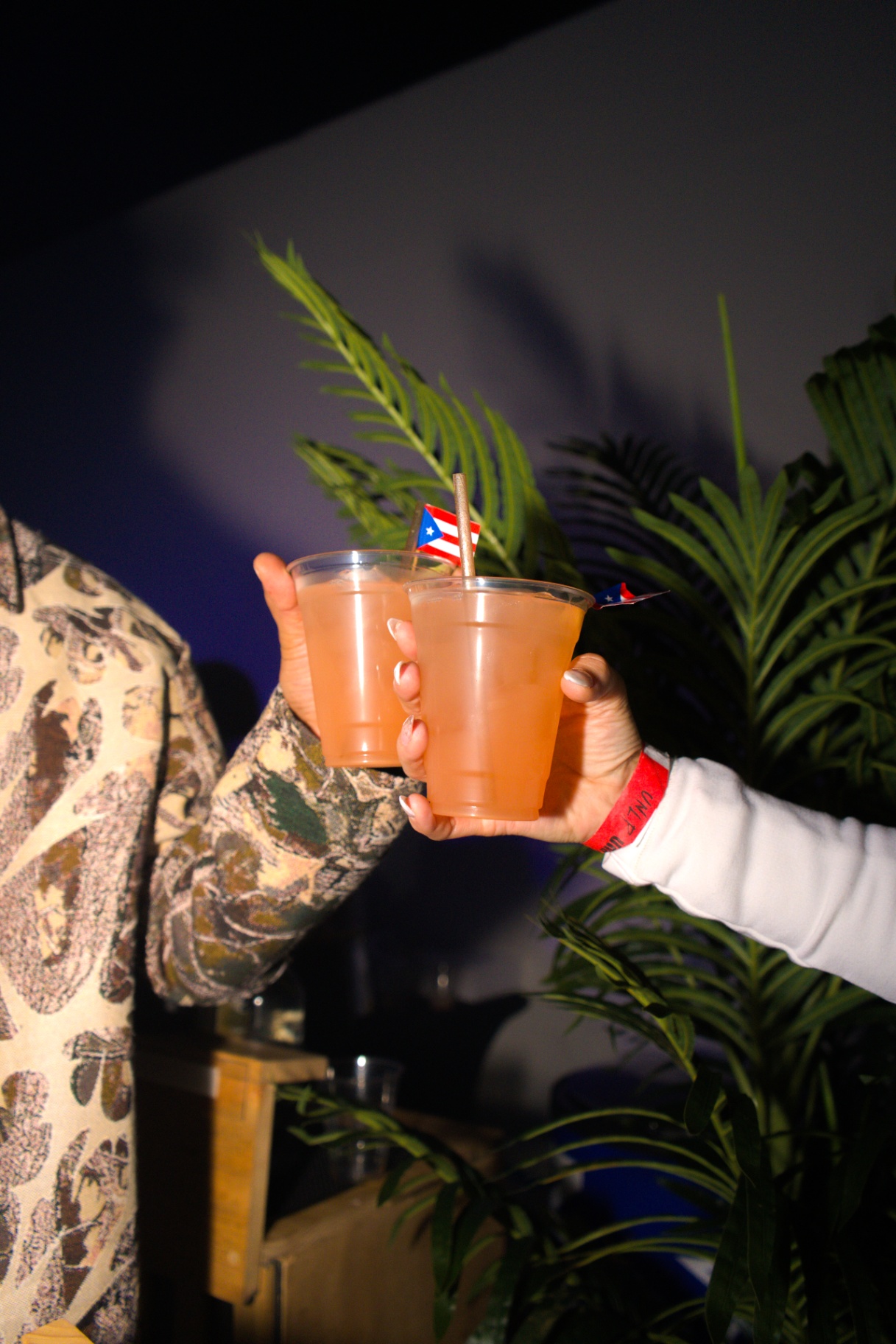 Two guests toasting cocktails with Puerto Rican flag picks